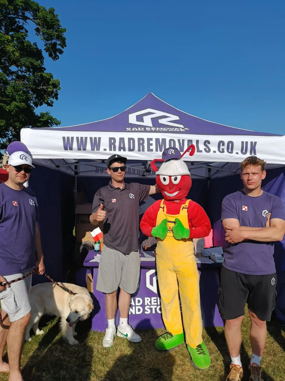 ANTBM Builder Merchants’ ant mascot wearing a RAD Removals hat at Polish Heritage Day 2025 in Hounslow, showcasing self storage West London and removal company South West London services.